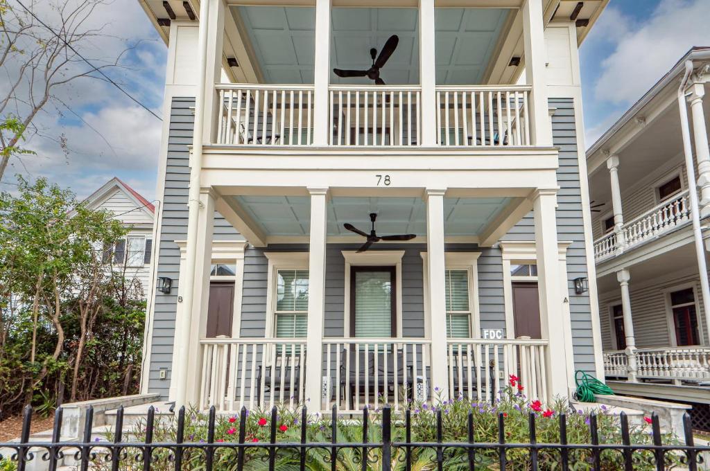 une maison blanche avec un balcon et une clôture dans l'établissement Patio Porches and Parking - 2 Blocks to King, à Charleston
