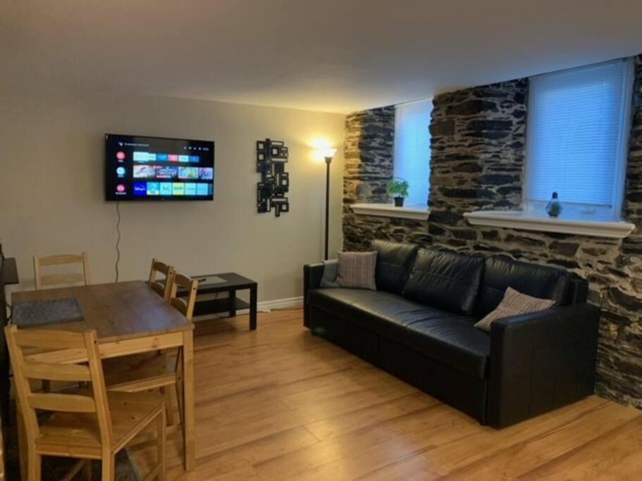 sala de estar con sofá negro y mesa en Cozy 1-bedroom in Bauer Terrace next to Citadel, en Halifax