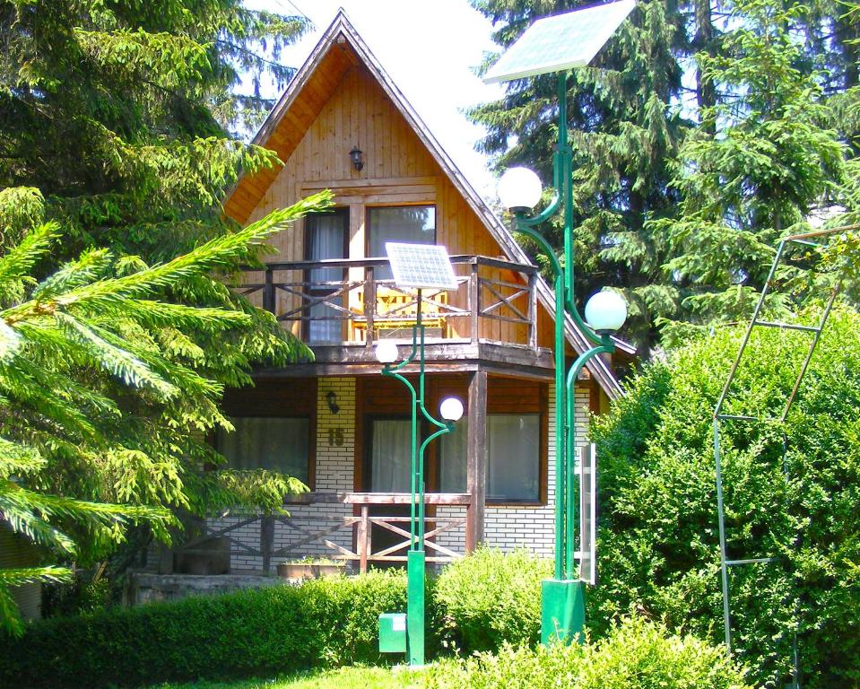 a small house with a balcony on the front of it at Traveland Alpina Resort Poiana Brasov in Poiana Brasov