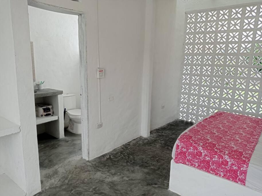 a white room with a bed and a bathroom at Casa de Recreo - Vacation House in Honda