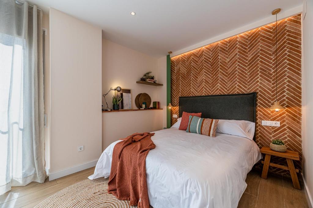 um quarto com uma cama grande e uma grande cabeceira. em Vestal Suites Domo em Cambrils