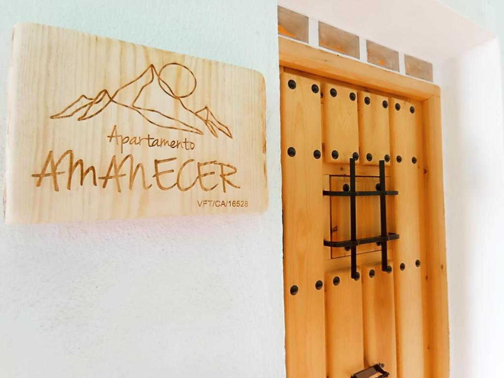 una puerta de madera con un cartel en la pared en APARTAMENTO AMANECER en Zahara de la Sierra