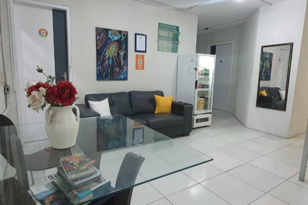 uma sala de estar com um sofá e uma mesa de vidro em Casa da Esquina Pousada em Recife