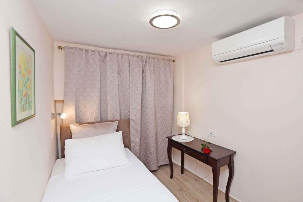ein Schlafzimmer mit 2 Betten und einem Tisch mit einer Lampe in der Unterkunft Holiday home in Dubrovnik 43524 in Dubrovnik
