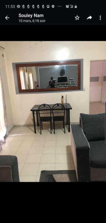 uma sala de estar com uma mesa e um sofá em Al Rayane em Dakar