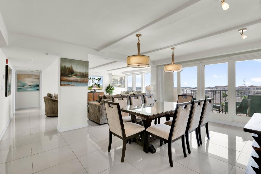 uma sala de jantar e sala de estar com mesa e cadeiras em Stunning Bayview! Large condo in beachfront resort with shared pools and jacuzzi em South Padre Island