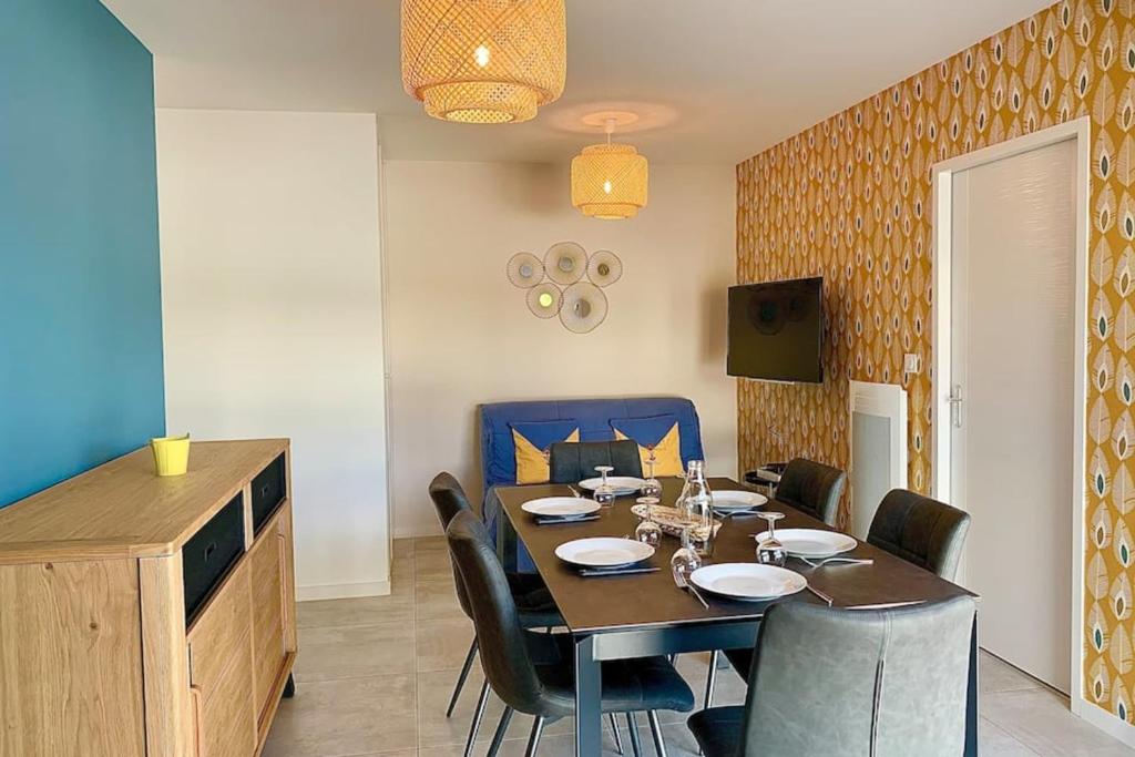une salle à manger avec une table et quelques chaises dans l'établissement L'Exotic - Plage de Boisvinet à Saint Gilles Croix de Vie, à Saint-Gilles-Croix-de-Vie