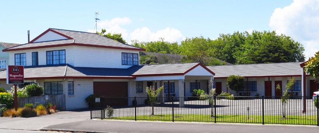 una casa bianca con una recinzione di fronte di BK's Magnolia Motor Lodge a Whanganui