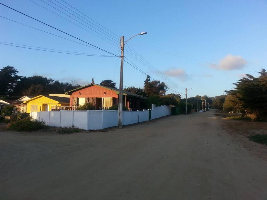 an empty street with a white fence and a house at Casa en Consistorial in El Tabo