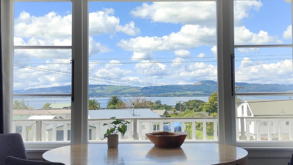 een groot raam met een tafel en uitzicht op het water bij Lake, mountain view cottage - near major attractions in Rotorua