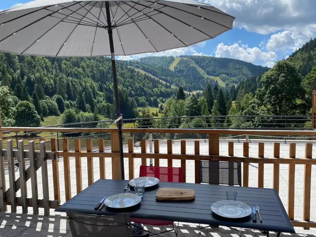 a blue picnic table with an umbrella on a balcony at Gîte La Bresse, 3 pièces, 4 personnes - FR-1-589-395 in La Bresse