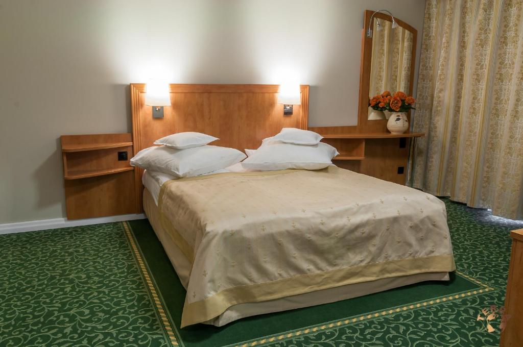 a bedroom with a large bed with white pillows at Pensiunea Terra in Bistriţa