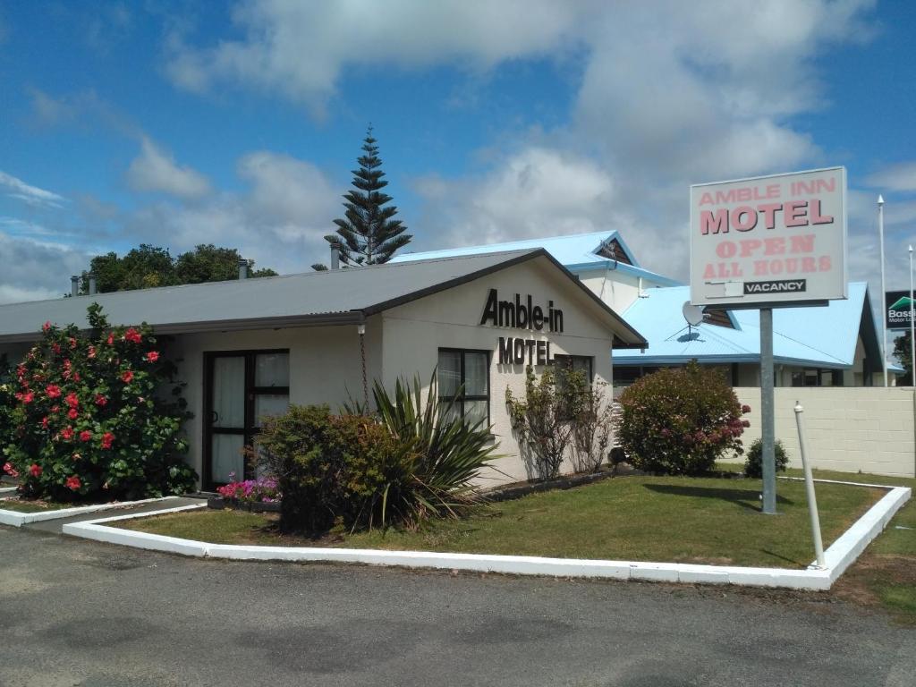 a motel with a sign in front of a building at Amble Inn Motel in Levin