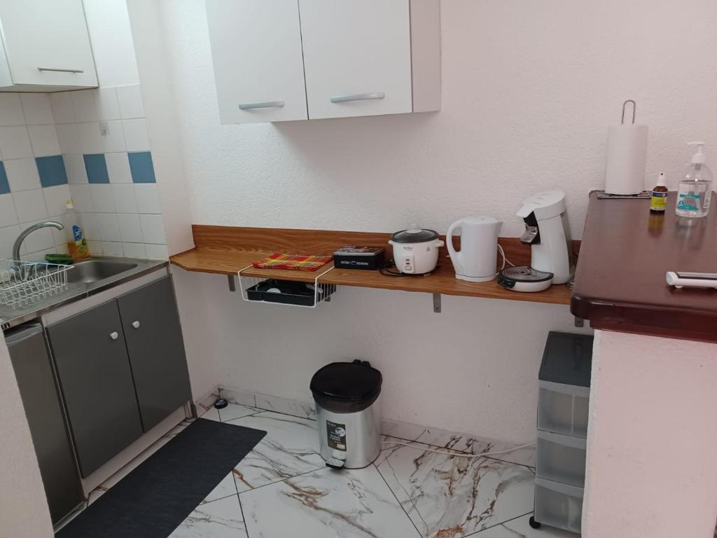 a dirty kitchen with a counter and a sink at Le Studio de Jo in Cayenne