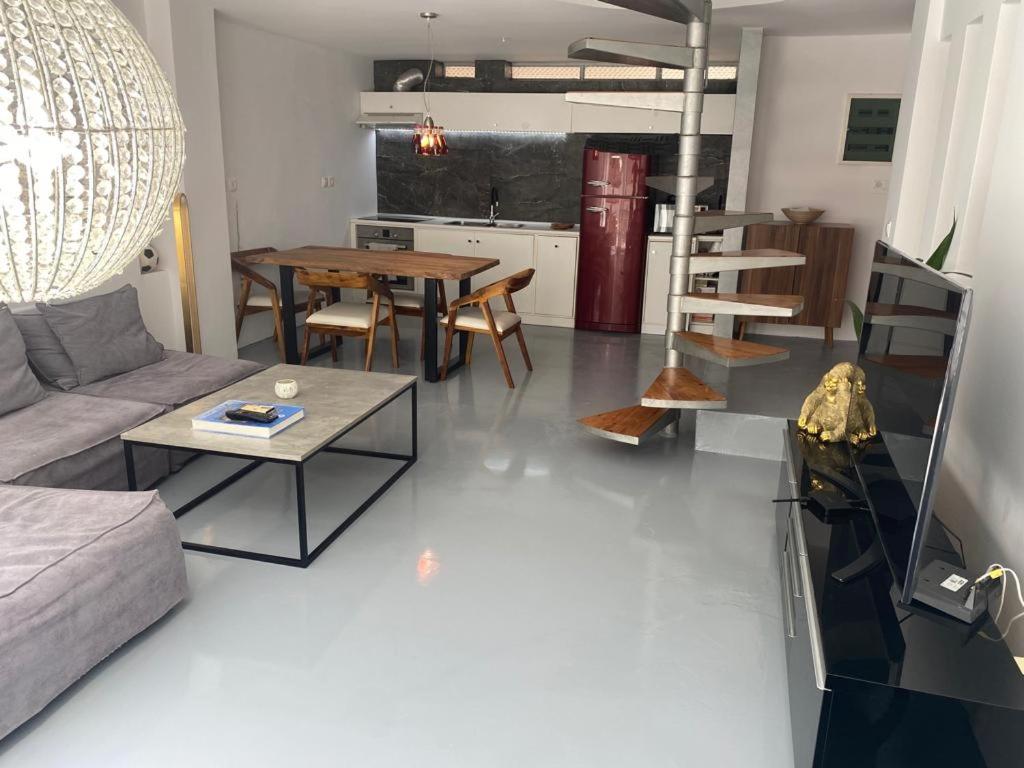 una sala de estar con un sofá y una mesa en Modern Maisonette / beach 5 min!, en Atenas