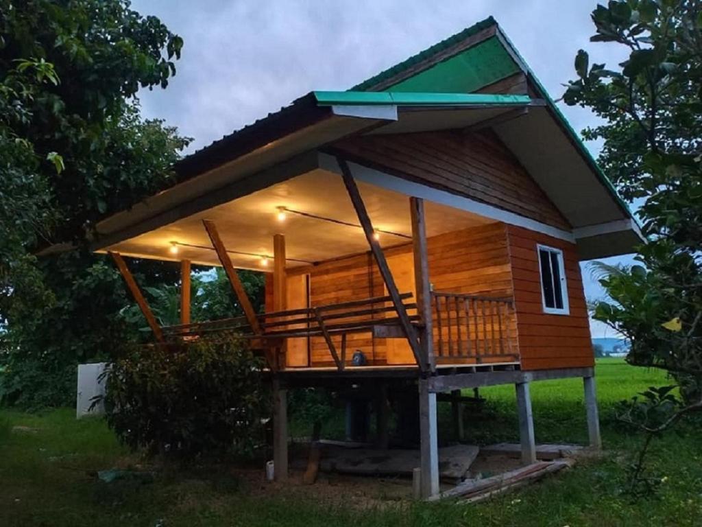 ein großes Holzhaus mit einer großen Terrasse in der Unterkunft Khunkorn Fishing Farm Stay in Ban Mae Kon