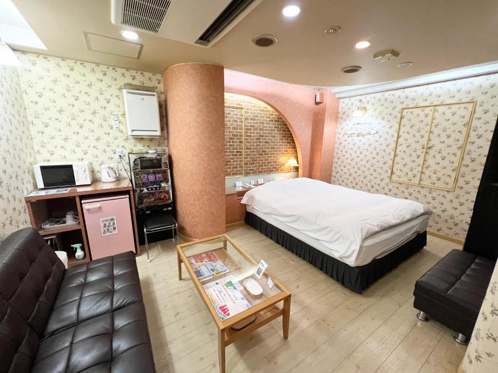 Habitación de hotel con cama y sofá en HOTEL MINT HOUSE -resort and relaxation-, en Mihama