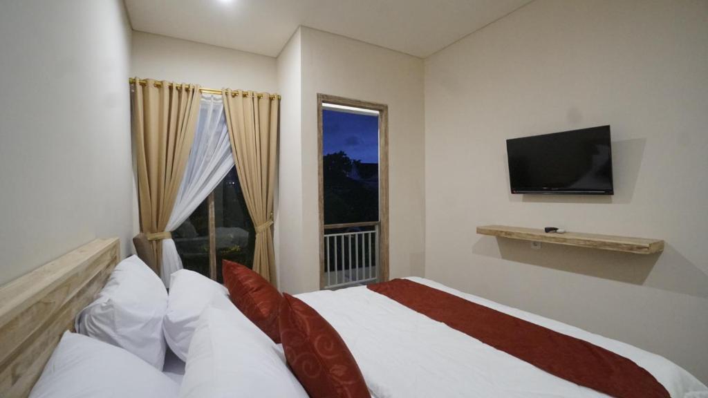 a bedroom with a bed and a large window at Maharani Residence in Denpasar