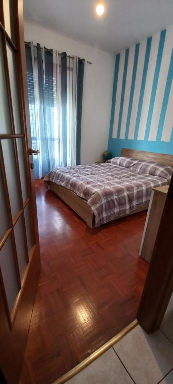 1 dormitorio con 1 cama y suelo de madera en La tesoriera, en Turín