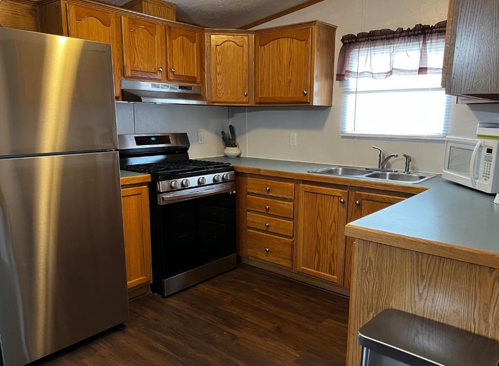 a kitchen with wooden cabinets and a stainless steel refrigerator at Stay in Ohiopyle in the center of it all, Ohiopyle, PA in Farmington