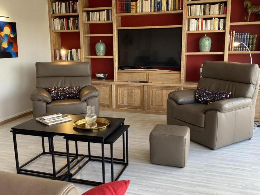 salon z 2 krzesłami i telewizorem w obiekcie Appartement lumineux à Moulins avec terrasse et proche centre - FR-1-489-413 w mieście Moulins
