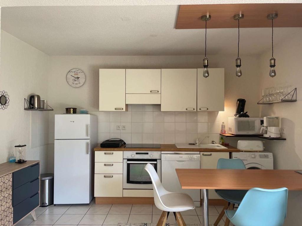 a kitchen with white appliances and a table and chairs at Appartement Capbreton, 2 pièces, 4 personnes - FR-1-239-872 in Capbreton