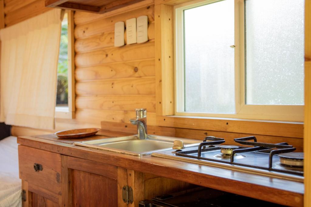 cocina con fregadero y fogones en Tiny House Remanso del Espíritu en Isla de Maipo