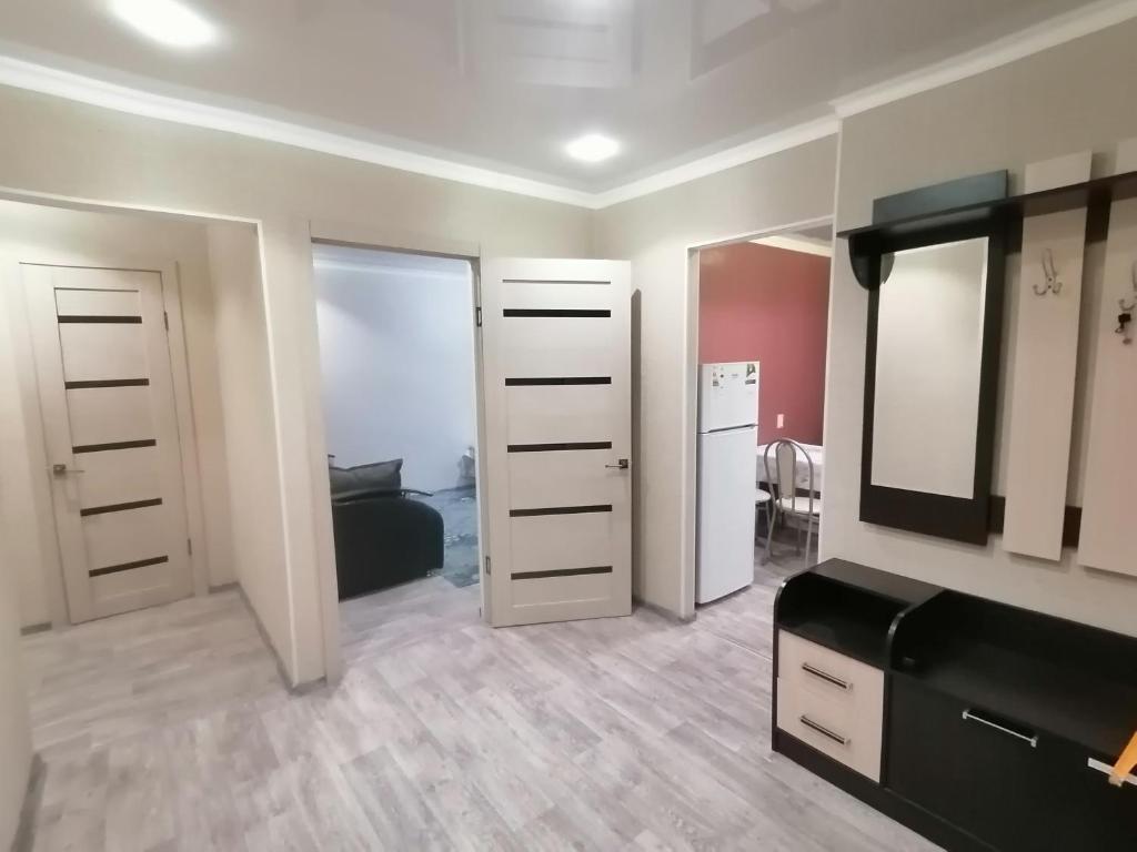 Zimmer mit einem Schlafzimmer mit einem Bett und einem Spiegel in der Unterkunft Квартира на Бр Жубановых 283 корпус 1 in Aqtöbe