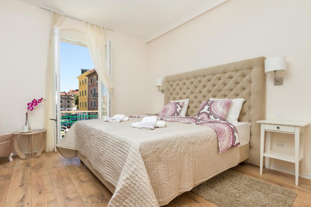 a bedroom with a large bed with a large window at Spalatum Boutique Suites in Split