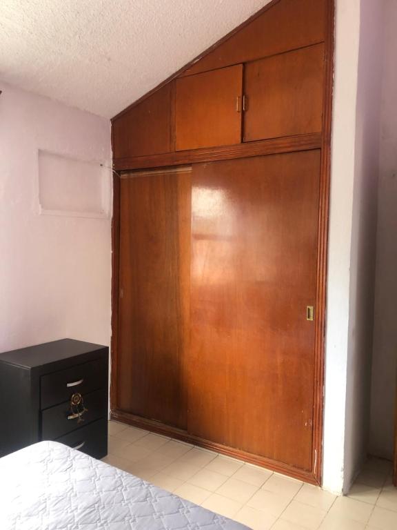 Una gran puerta de madera en un dormitorio con cama en Tláloc House, en Tuxtla Gutiérrez