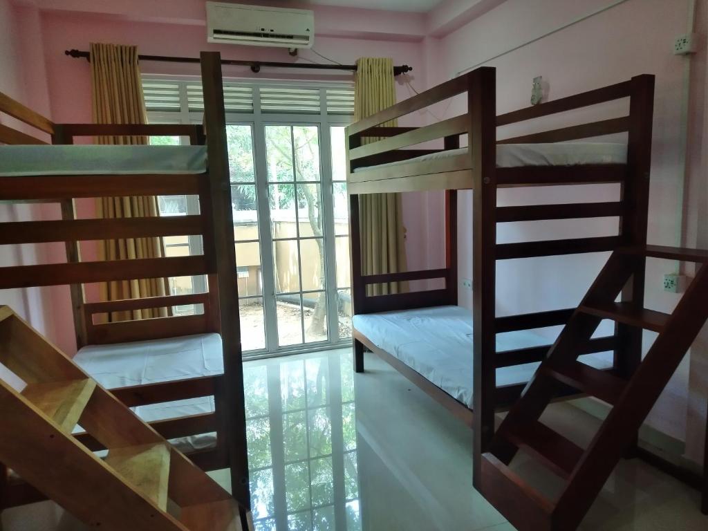 Cette chambre comprend 2 lits superposés et une fenêtre. dans l'établissement Cross Ceylon, à Negombo