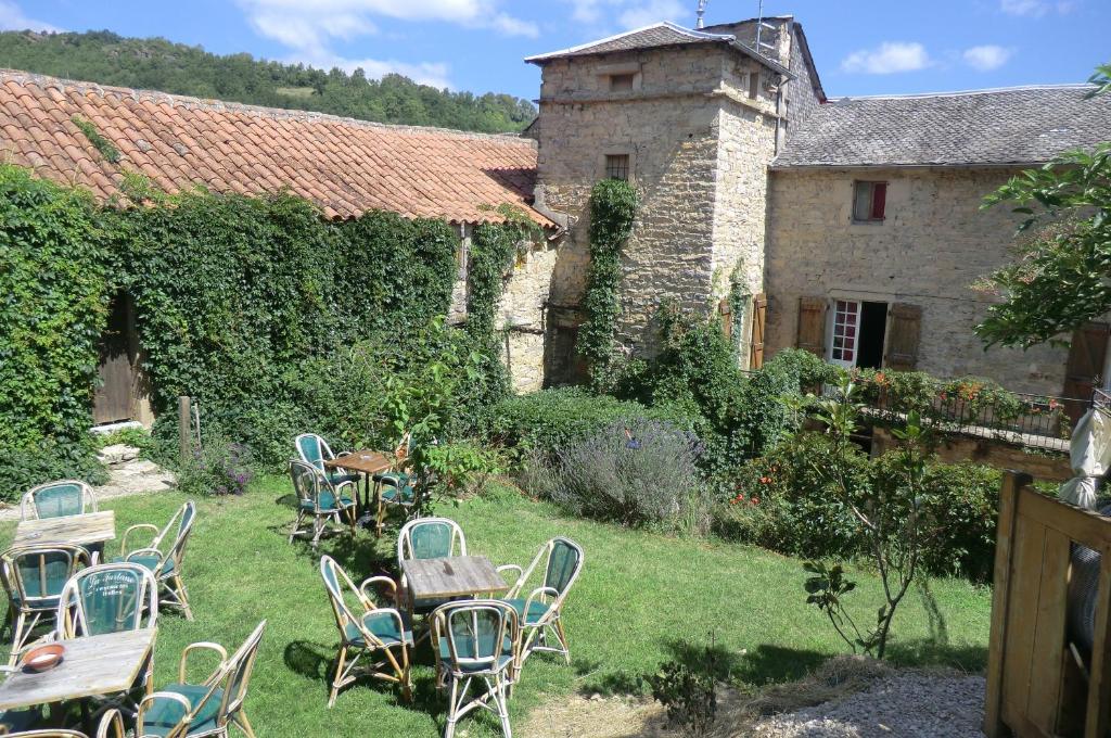 um grupo de cadeiras e mesas no pátio de um edifício em Domaine d'Alcapiès em Saint-Jean-dʼAlcapiès