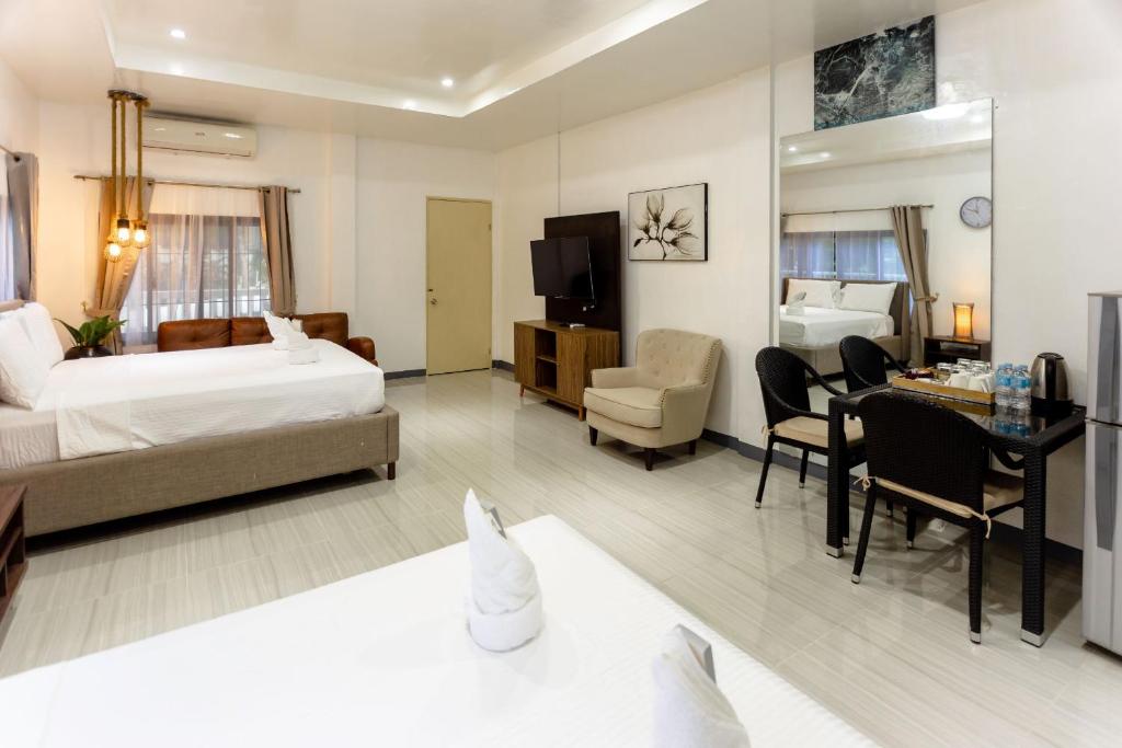 um quarto de hotel com uma cama e uma sala de estar em MADISON GARDEN AND RESIDENCES em Panglao