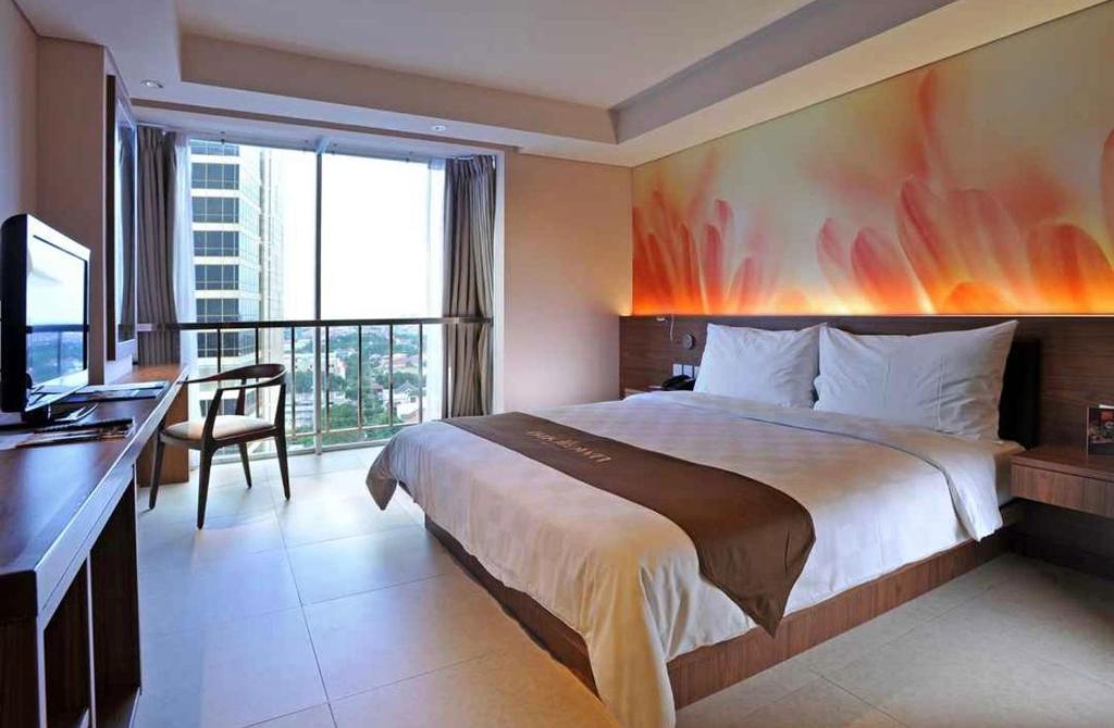 Postel nebo postele na pokoji v ubytování Midtown Hotel Surabaya