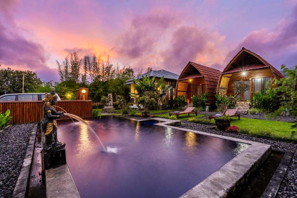 a home with a water fountain in the yard at KINTAMANI Paradise Villa in Kintamani