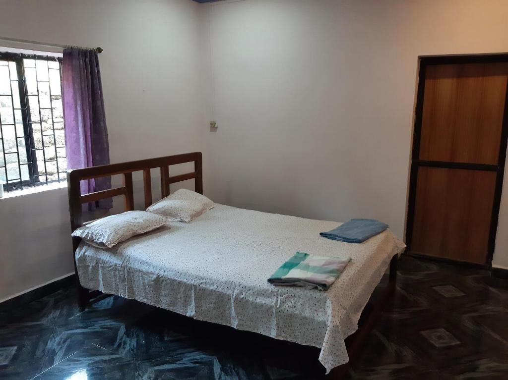 a small bedroom with a bed and a window at Dias guest house in Canacona