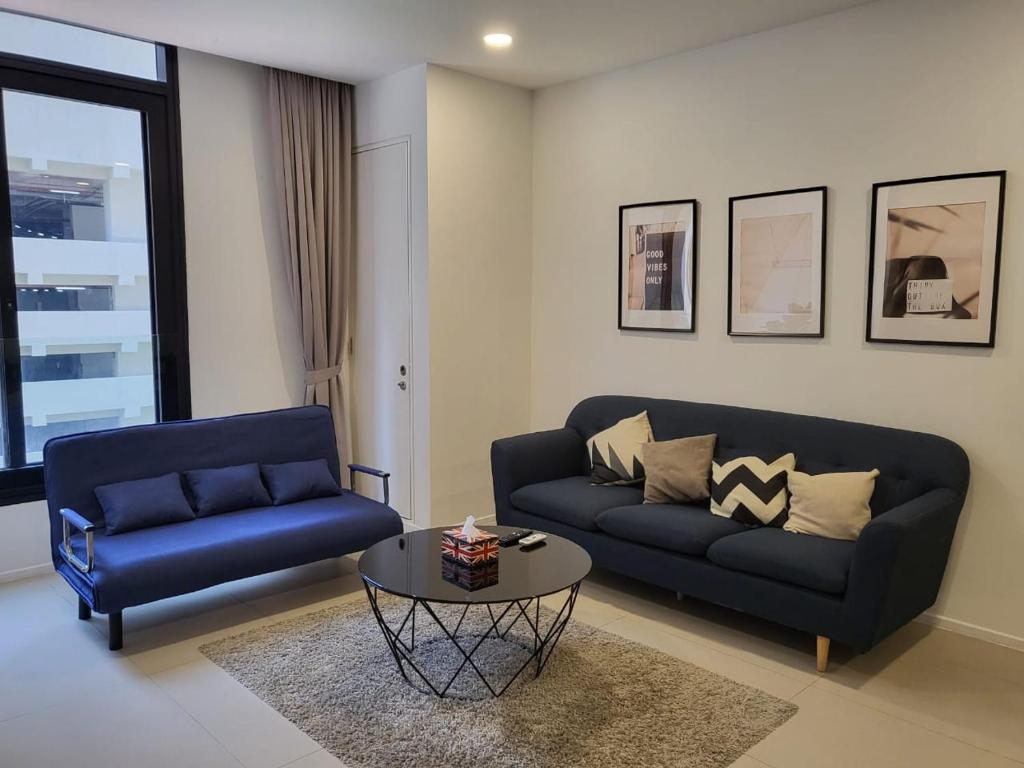 - un salon avec un canapé bleu et une table dans l'établissement 1-4pax Modern Furnishing Arcoris-5 min to 163 mall, à Kuala Lumpur