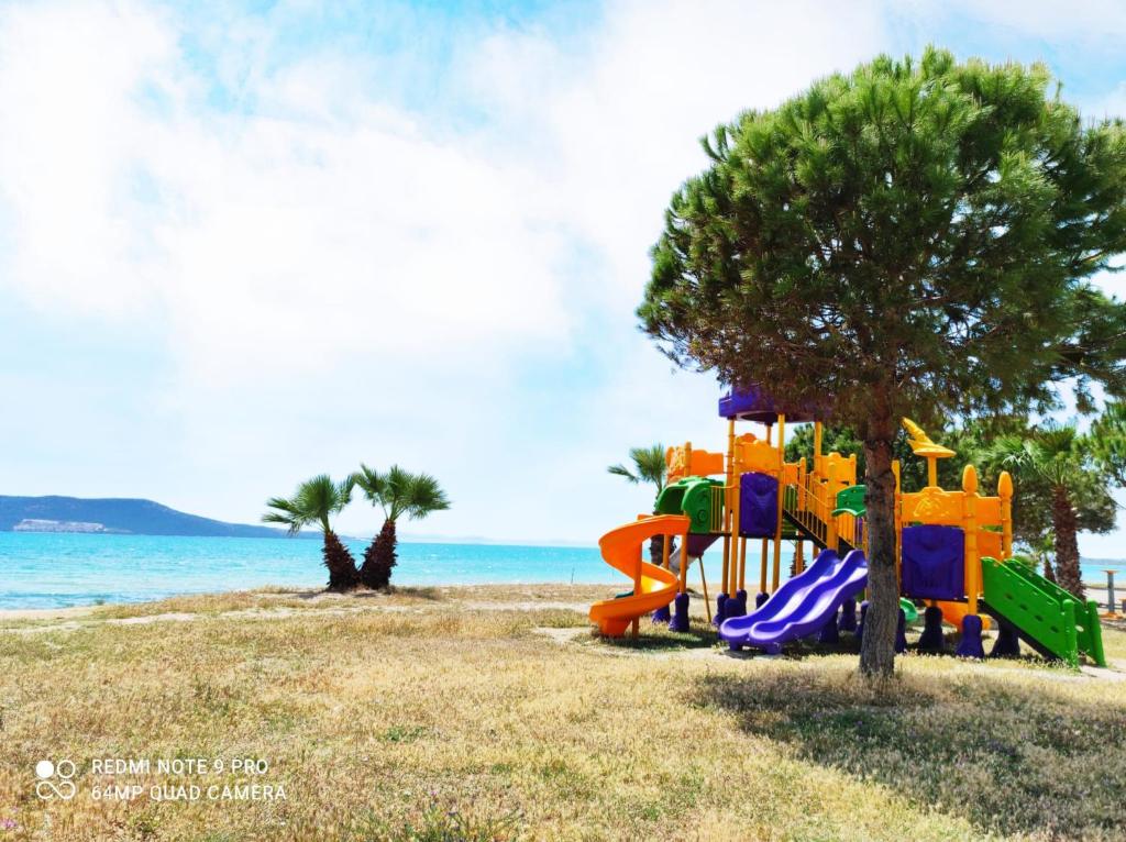 a playground on a beach with the ocean in the background at Stilvolle Villa mit Strandlage in Didim