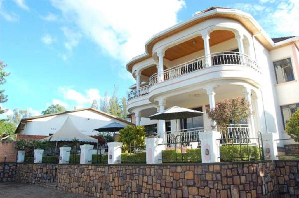 a large white building with a balcony on a wall at Step Town in Kigali