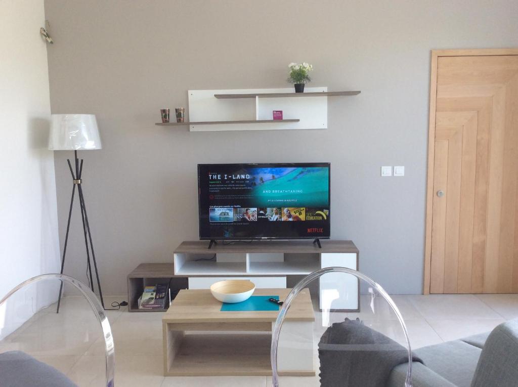 un soggiorno con TV a schermo piatto su un tavolo di 65/66 South Beach Apartment a Blue Bay