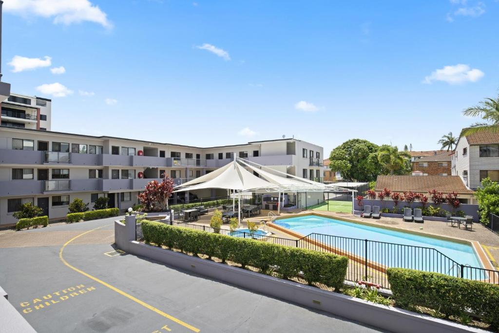 an apartment complex with a swimming pool and a building at Harbour Side Resort in Gold Coast