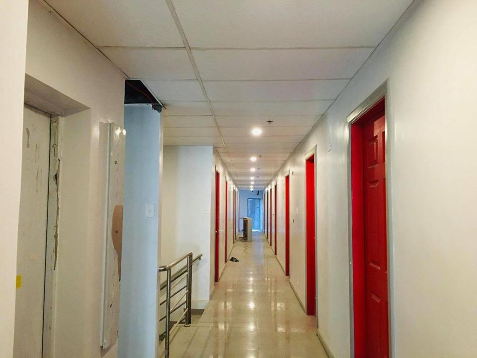 an empty hallway with red doors and a hallwayngthngthngthngthngthngthngth at ML SUITES CEBU in Cebu City