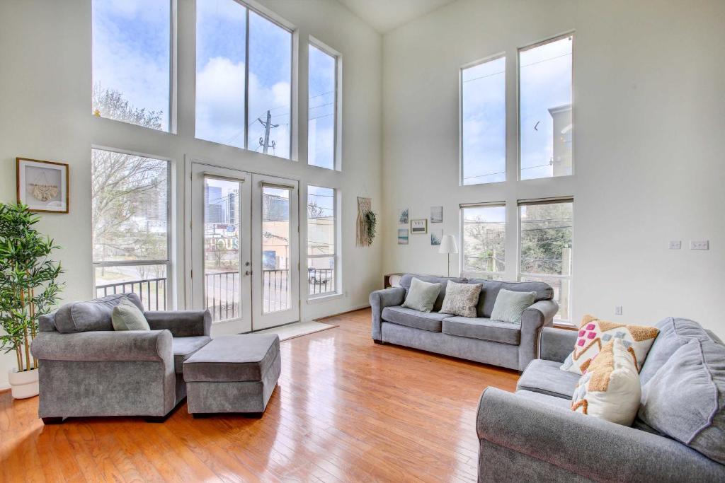 a large living room with two couches and windows at Downtown Houston Townhome with City Views! in Houston