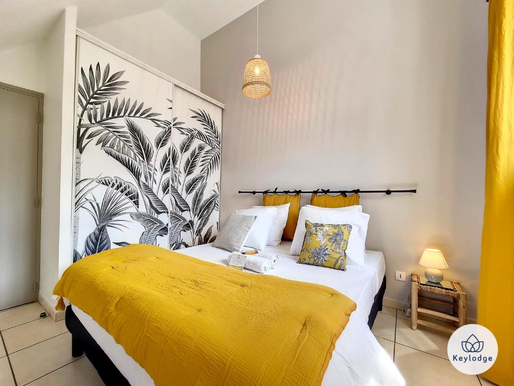 um quarto com uma cama grande e um cobertor amarelo em Leu Bengali - 3 étoiles - T4 duplex à Saint-Leu em Saint-Leu