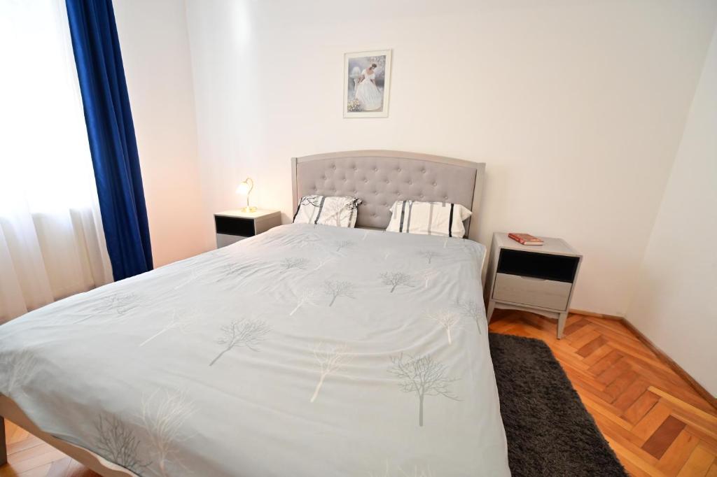 um quarto com uma cama grande e lençóis brancos em Apartament cu 2 dormitoare, Benjamin Residence, Piata Mare em Sibiu