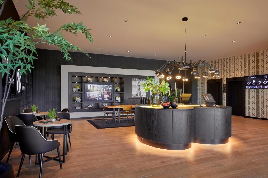 un vestíbulo con bar, mesas y sillas en Gr8 Hotel Breda, en Breda