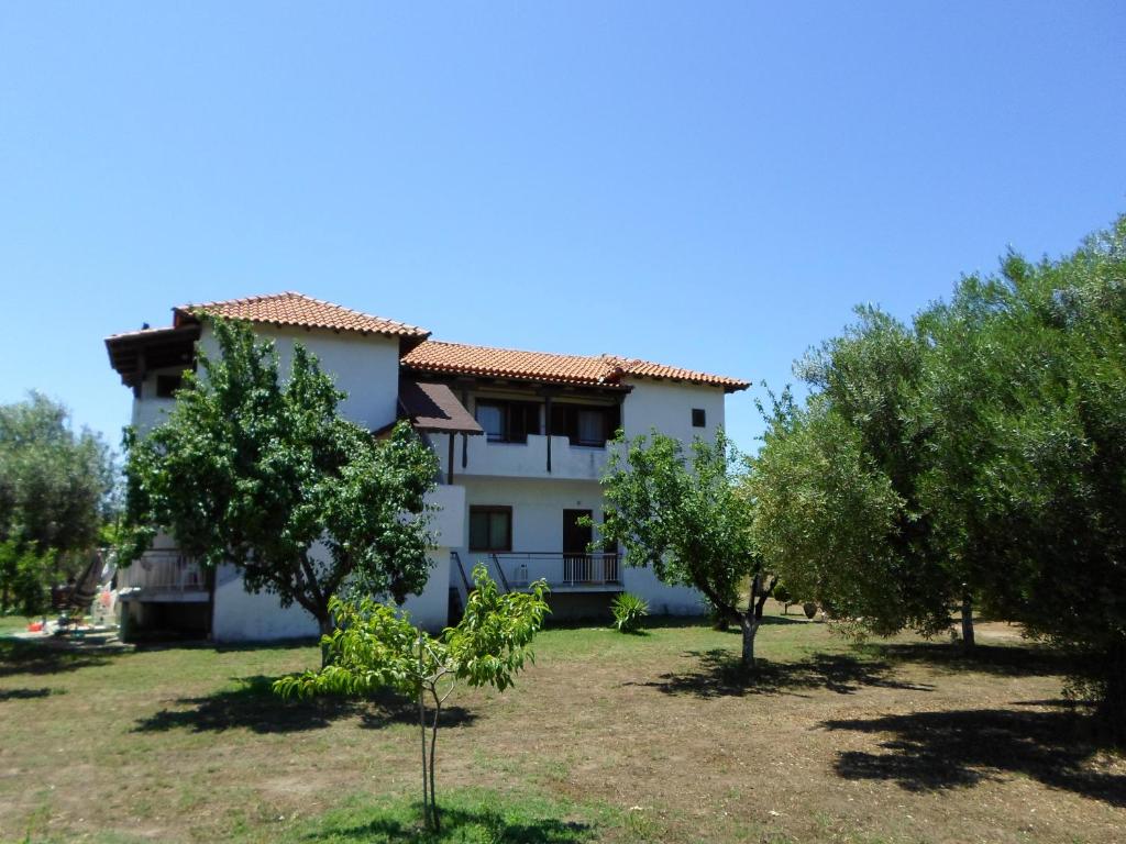 una casa con árboles delante de ella en Bozelia Apartments, en Toroni