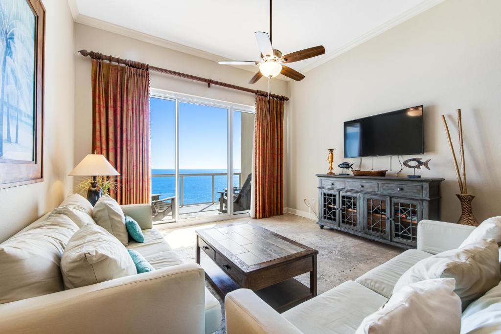 a living room with a couch and a tv at Caribbean Resort 1802 in Navarre