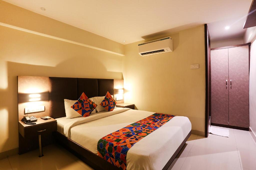 a hotel room with a bed and a night stand at FabHotel West Inn in Mumbai