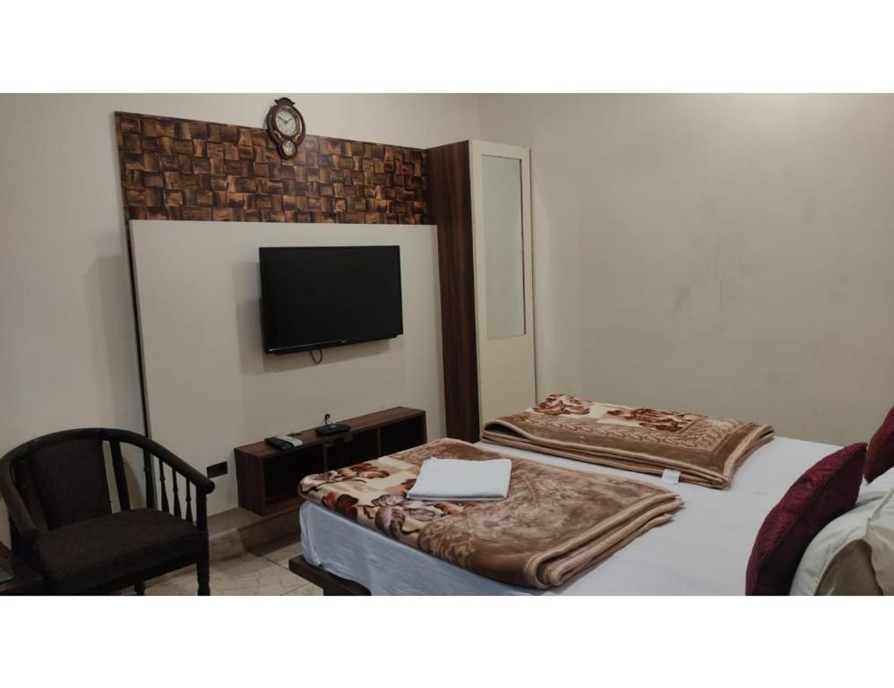 a hotel room with two beds and a flat screen tv at Hotel Mayur Classic, Ludhiana in Ludhiana